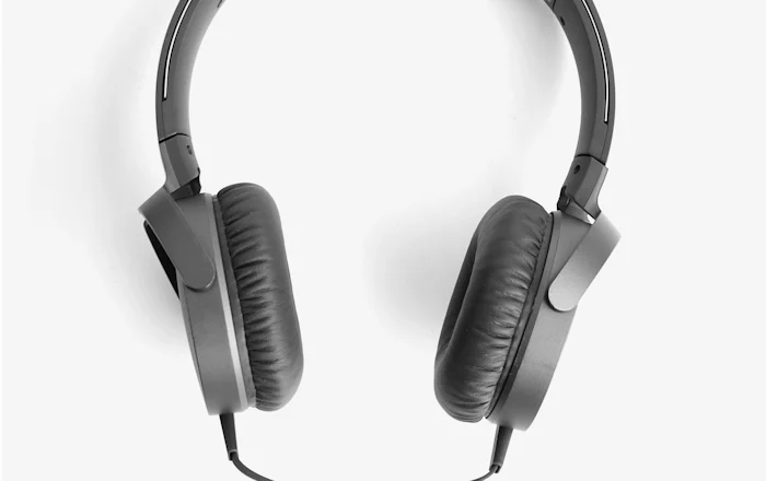 Over-ear headphones resting on a wooden surface in soft daylight