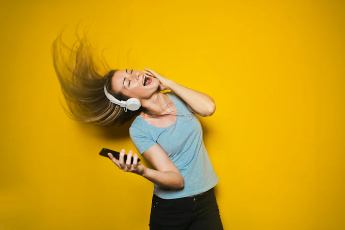 Person wearing over-ear headphones with soft blue light behind them