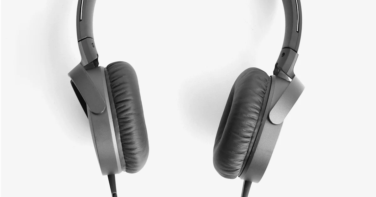 Over-ear headphones resting on a wooden surface in soft daylight